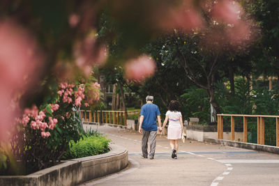 Rear view of couple walking on road