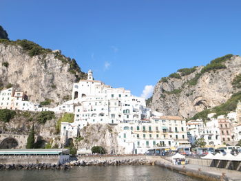 Buildings in town against clear blue sky