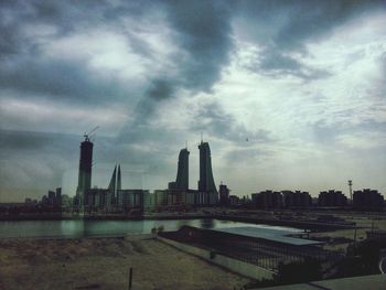 View of cityscape against cloudy sky