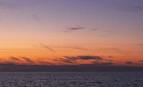 Scenic view of sea against romantic sky at sunset