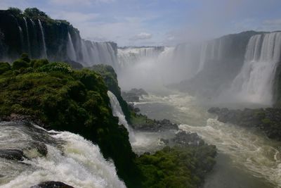 Scenic view of waterfall against sky