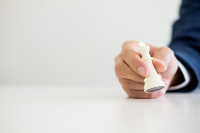 Close-up of man holding hands over white background