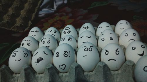 Close-up of anthropomorphic faces on eggs at bed