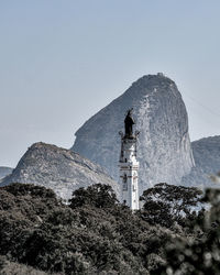 Low angle view of lighthouse amidst buildings against sky