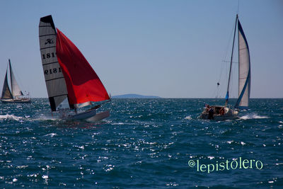 Boats in sea against clear sky