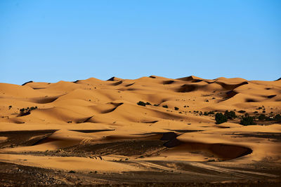 Scenic view of desert against clear blue sky