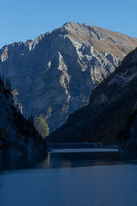 Scenic view of lake by mountains against sky