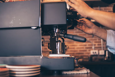 Midsection of man working in coffee at cafe