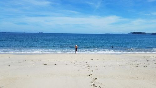 Full length of man walking on beach against sky