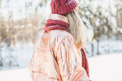 Rear view of woman against trees on snowy field