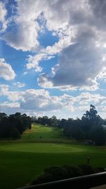 Scenic view of grassy field against cloudy sky