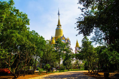 Trees and temple against blue sky