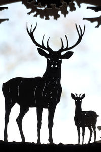 Silhouette deer standing against sky