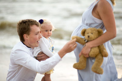 Man with daughter and woman at beach