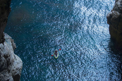 High angle view of people on rock by sea