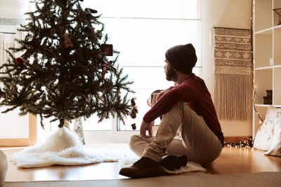 Rear view of woman sitting at home