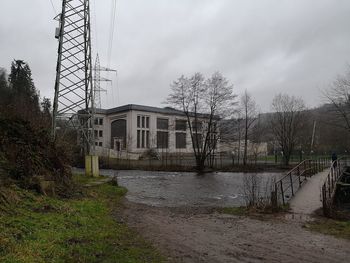 Canal by buildings against sky