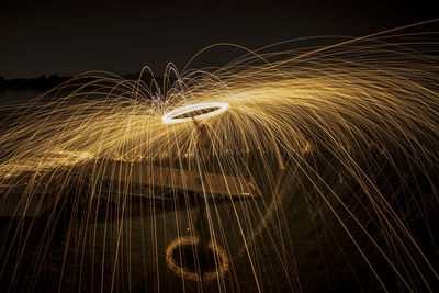 Man standing amidst wire wool at night