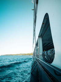 Sailboat sailing in sea against clear blue sky