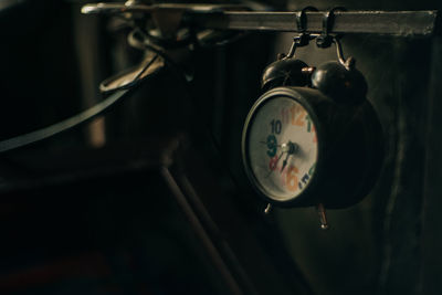 Close-up of clock hanging on metal