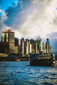 Sea by buildings against sky in city