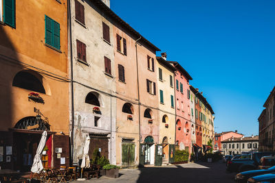 Street amidst buildings against blue sky