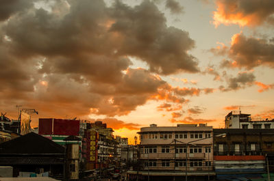 Houses in town against sky during sunset