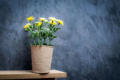 Close-up of yellow flower pot against wall