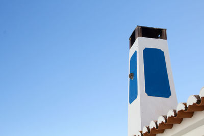 Low angle view of cross against clear blue sky