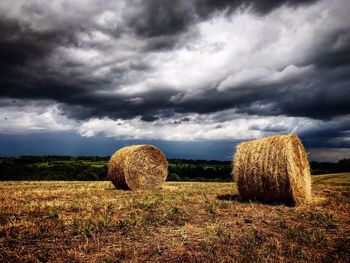 Hay bales on field against sky