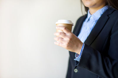 Midsection of woman holding coffee cup