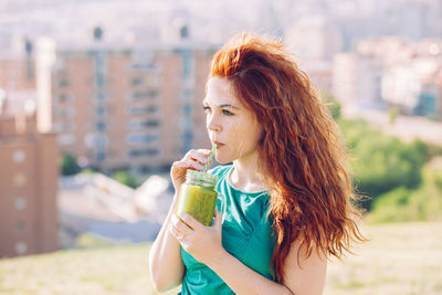 Portrait of woman drinking water