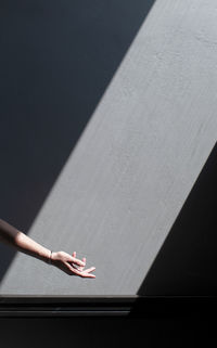 Cropped hand against gray wall