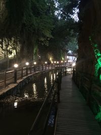 Footbridge over river in city at night