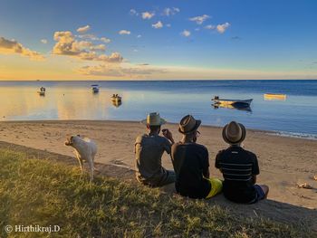 Rear view of people sitting on beach