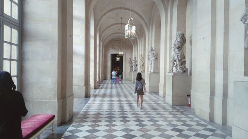 Rear view of women in corridor of building