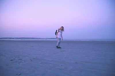 Man standing on beach against clear sky