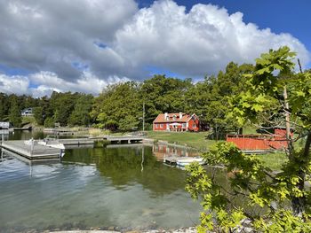 Houses by lake against sky