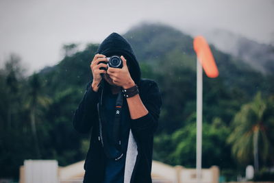 Close-up of woman photographing against sky