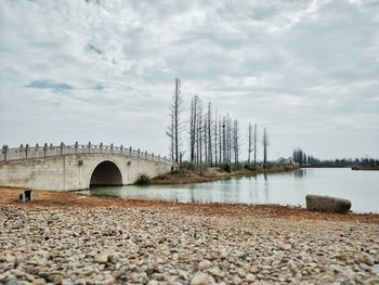 View of bridge over river against cloudy sky