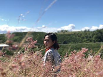 Side view of woman standing on field against sky