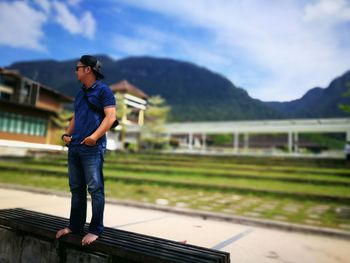 Full length of man standing on mountain against sky