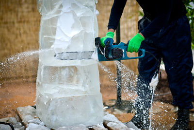 Low section of man making ice sculpture