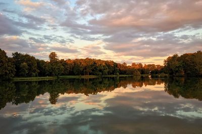 Reflection of trees in lake against sky during sunset