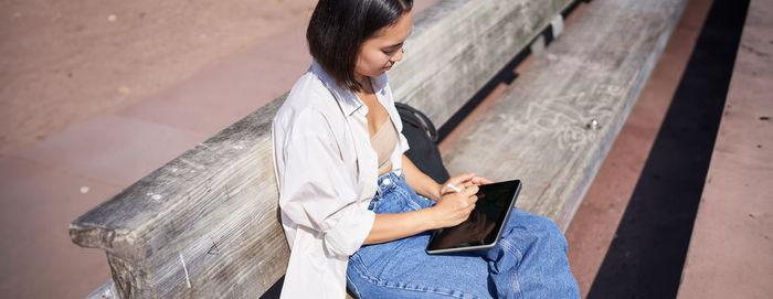 Side view of young woman using mobile phone