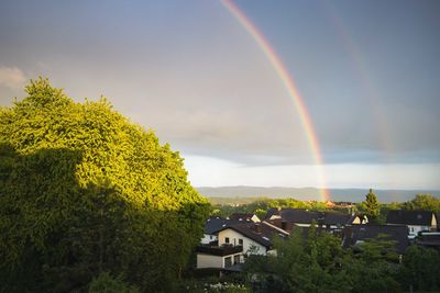 Scenic view of rainbow over buildings against sky