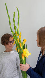 Portrait of woman holding yellow flower