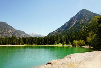 Scenic view of lake and mountains against clear sky