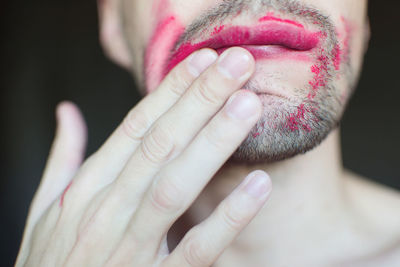 Midsection of transgender man with red lipstick