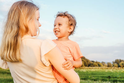 Mother and son on field against sky